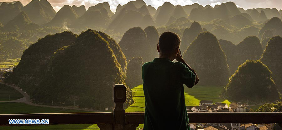 (120801) -- XINGYI, agosto 1, 2012 (Xinhua) -- Un visitante toma fotograf¨ªas en Wanfenglin en Xingyi, de la provincia de Guizhou, al suroeste de China, el 31 de julio de 2012. Wanfenglin, que significa literalmente "Bosque de los Diez Mil Picos", es un Parque Geol¨®gico Nacional y una atracci¨®n turistica de la ciudad de Xingyi.  (Xinhua/Liu Xu) (rh) (py)