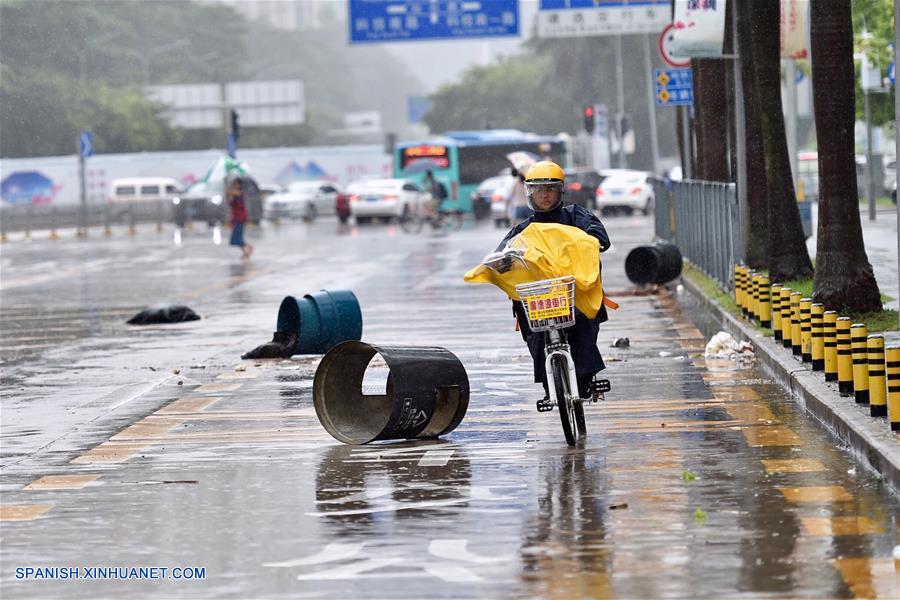 Un trabajador de entrega de comida conduce una bicicleta en medio de la lluvia en Shenzhen, en la provincia de Guangdong, en el sur de China, el 23 de agosto de 2017. (Xinhua/Mao Siqian)