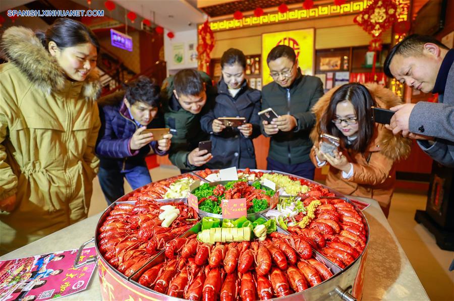  JIANGSU, enero 23, 2018 (Xinhua) -- Personas toman fotografías de cangrejos de río en un restaunante, en el condado de Xuyi de Huai'an, provincia de Jiangsu, en el este de China, el 23 de enero de 2018. El cangrejo de río es la famosa especialidad del condado de Xuyi y la demanda de cangrejos aumenta a medida que el Festival de Primavera se acerca. (Xinhua/Zhou Haijun)