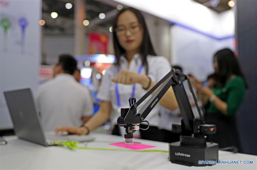 Una mujer manipula brazos mecánicos mediante tecnología 5G durante la 16 Feria Internacional de Servicios de Software e Información de China, en Dalian, provincia de Liaoning, en el noreste de China, el 12 de junio de 2018. La feria de servicios comenzó el martes en Dalian, con la participación de 750 expositores. (Xinhua/Yang Qing)