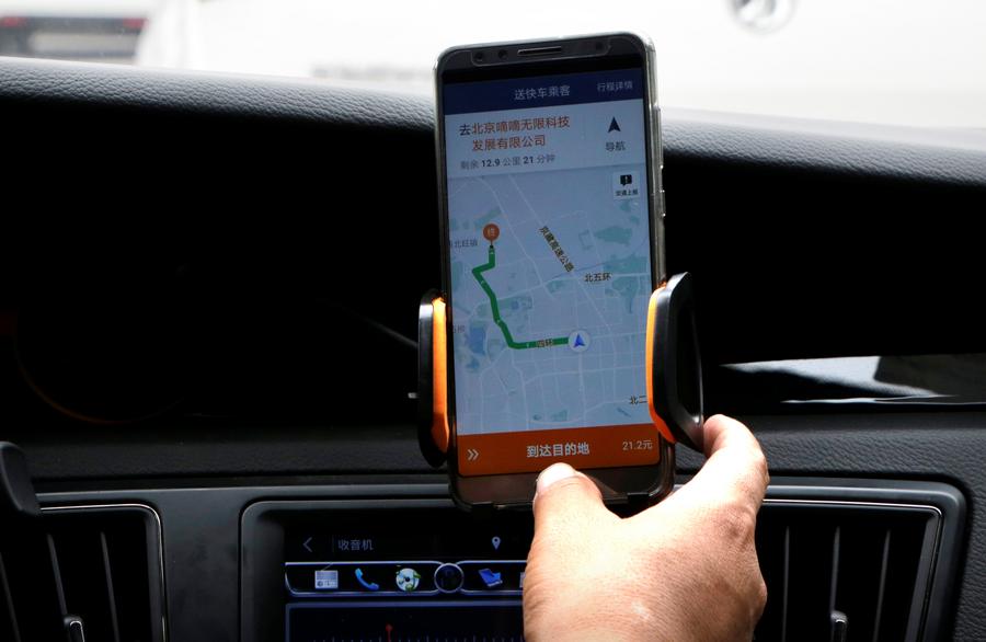 A Didi Chuxing driver checks the information on the application in his car in Beijing, China August 28, 2018. REUTERS/Jason Lee